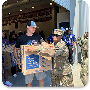 Ally veterans moving boxes at a volunteer event.