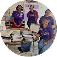 a smiling group of Ally employees displaying financial workbooks.