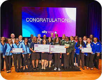 a group of smiling students and Ally employees displaying donations.